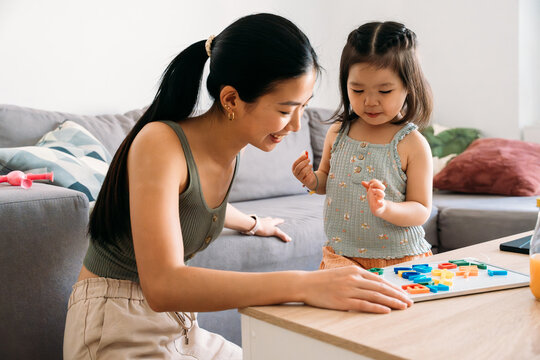 Mother and daughter playing with colorful alphabet game