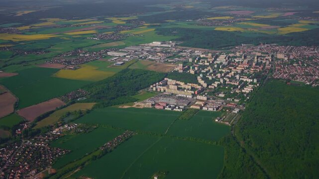 Aerial view of suburban city, forest and fields.