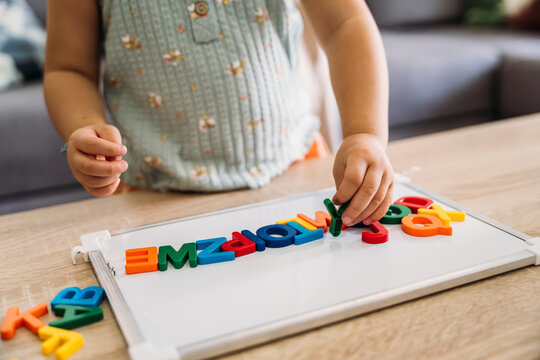 Child learning alphabet with colorful magnetic letters