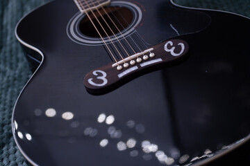 Close-up detail of acoustic guitar strings, showing metal texture and warm wooden tones. Musical...