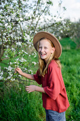 Girl enjoying spring blossoms in garden.