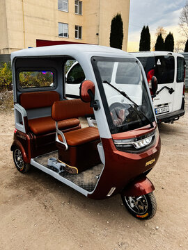 Modern electric auto rickshaw FADA NiMBUS MEGA 1200W with brown leather seats in an urban setting