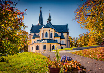 Wonderful autumn view of Basilica of the Virgin Mary (place of pilgrimage) among trees covered with...