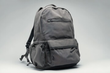 Fototapeta premium Gray everyday backpack with front pocket and zipper details on white surface