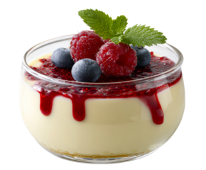 Creamy vanilla panna cotta dessert in a glass is garnished with fresh raspberries, blueberries, dripping berry sauce, and a vibrant mint leaf for an elegant presentation