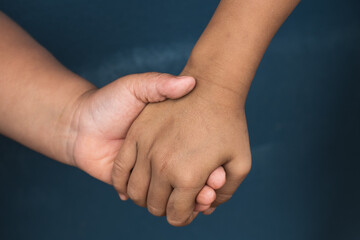 Two hands hold tightly to each other, rescuer saves, the concept of helping someone in need.