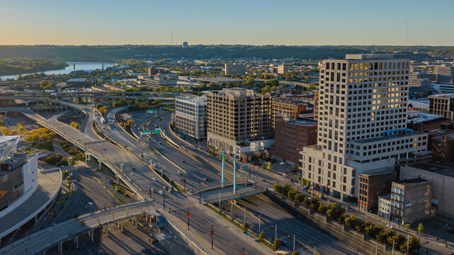 Aerial view of highways threading through buildings, reflecting the golden hour's light, showcasing Cincinnati's urban landscape., Cincinnati, Ohio, United States.