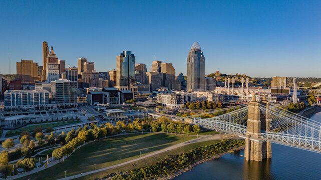 Aerial view of the majestic John A. Roebling Suspension Bridge, its stone towers anchoring the skyline against the vibrant city, Covington, Kentucky, United States.
