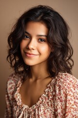 Fototapeta premium Head-and-shoulders portrait of a cheerful Latina woman with a warm background
