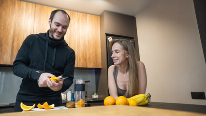 A Caucasian couple prepares freshly squeezed juice.