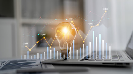 A modern office scene featuring a glowing light bulb symbolizing innovative ideas above a laptop with financial graphs, showcasing data analytics and business growth. Scalp