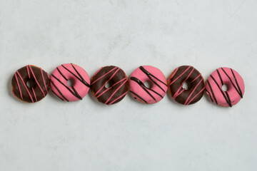 Symmetrical Row of Pink and Chocolate Donuts