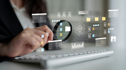 A professional analyzes digital data using a magnifying glass on a transparent screen, showcasing virtual graphics and AI elements in a modern office environment. Gantry