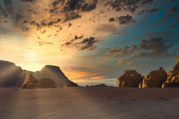 Sunset over rocky landscape setting with clouds on sky. Wadi Rum desert, Jordan, The Valley of Moon