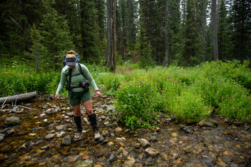 Backpacker Attempts To Keep Feet Dry While Crossing Creek In Grand Teton