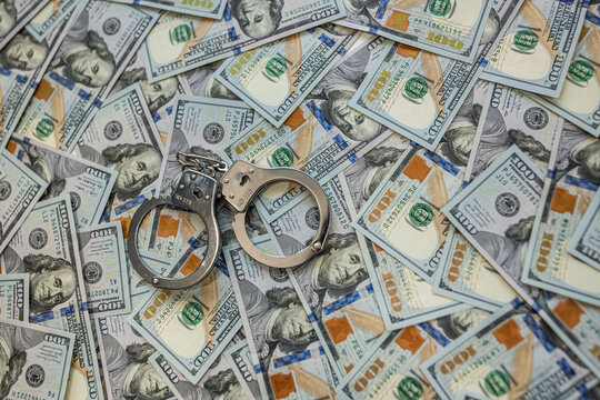 Handcuffs on dollar bills symbol of corruption and financial crime