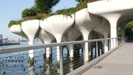 Naklejka premium New York City Little Island pier park, oasis in Manhattan Midtown, United States. Urban architecture on pillars in Chelsea, USA. Futuristic contemporary concrete columns design, Hudson river landmark.
