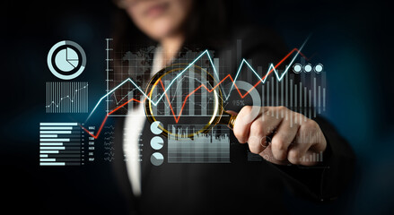 A businesswoman uses a magnifying glass to analyze financial data and trends, showcasing the importance of technology in modern market research and business strategy. Scalp