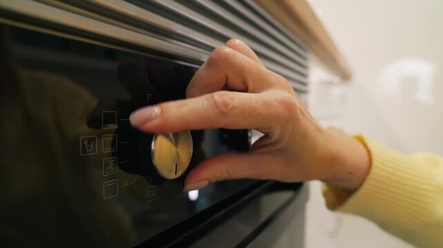 Unrecognizable woman turning  temperature knob and choose cook program on modern black built in oven while prepare to bake or cook homemade food in kitchen