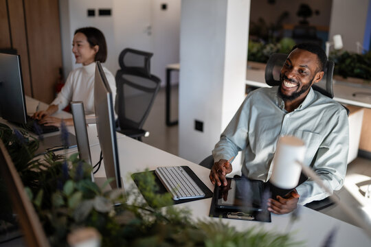 Diverse coworkers collaborating in modern open-plan office - Powered by Adobe