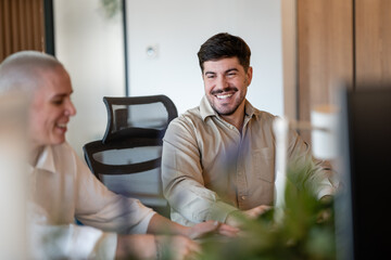 Fototapeta premium Happy young businessman collaborating in modern office environment