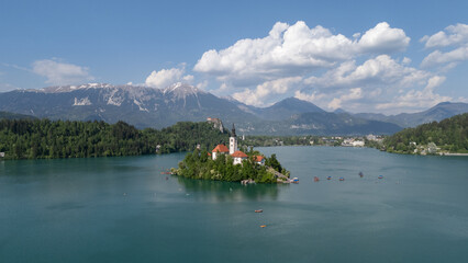 Aerial drone view of Bled Island with the Church of the Assumption in the middle of Lake Bled, Slovenia. The iconic island church is surrounded by turquoise alpine waters and forested mountains. Famou