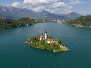 Aerial drone view of Bled Island with the Church of the Assumption in the middle of Lake Bled, Slovenia. The iconic island church is surrounded by turquoise alpine waters and forested mountains. Famou