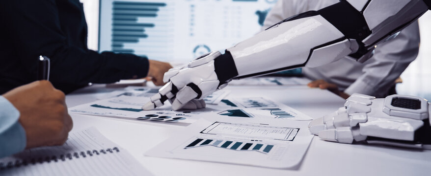 A robotic arm interacts with business charts and documents in a modern office. Professionals collaborate on data analysis to drive insights for strategic decision-making.Noogenesis - Powered by Adobe