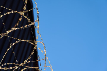 Barbed wire against a clear blue sky.