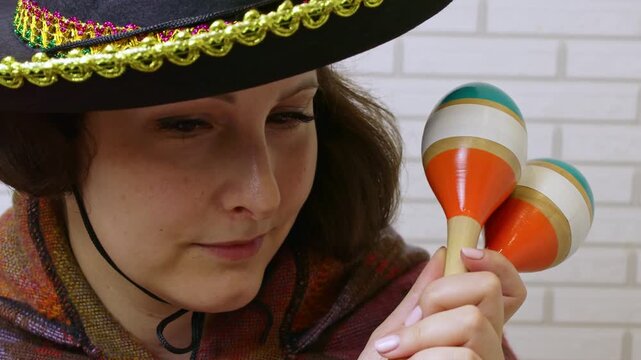 Woman holding in her hands and playing maracas musical instrument