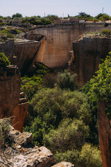 Dramatic limestone quarry labyrinth in Menorca. Abstract, textured stone walls.