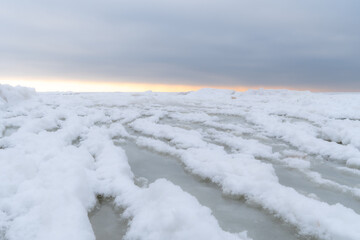 Frozen Sea Ice with Snowy Ridges Under Soft Winter Horizon Glow, Minimalist Baltic Seascape Expressing Silence, Cold Stillness and Subtle Northern Light © Edijs