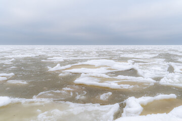 Frozen Baltic Sea with Scattered Drift Ice and Soft Overcast Sky, Minimalist Winter Seascape with Vast Negative Space and Subtle Northern Tones © Edijs