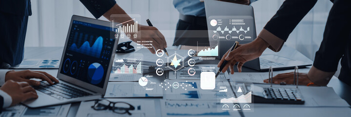 A collaborative business meeting showcasing data analytics on laptops, detailed charts, and professional engagement in a modern workspace focused on strategic solutions. Trope