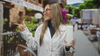 Woman holding pump bottle and pointing finger on a street while smiling in a white coat; cheerful promotion.