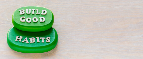 Build good habits words on green wooden blocks. Motivation and self-development concept. Banner with free space for additional concept.