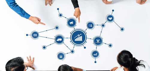 Diverse business team collaborating on strategies and insights, pointing at graphical data on a large table. Ideal for teamwork and analytics representation. Amity