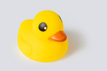 Yellow rubber duck toy isolated on gray background, symbolizing bath time and play