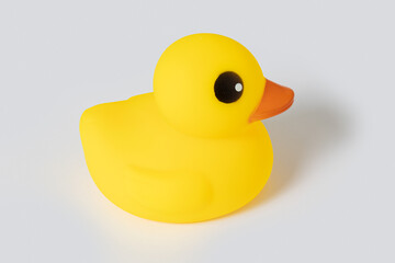 Yellow rubber duck toy isolated on gray background representing childhood fun
