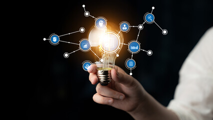 A hand holding a glowing light bulb surrounded by icons representing creativity and innovation. Perfect for visuals related to ideas, technology, and business solutions. Tessel