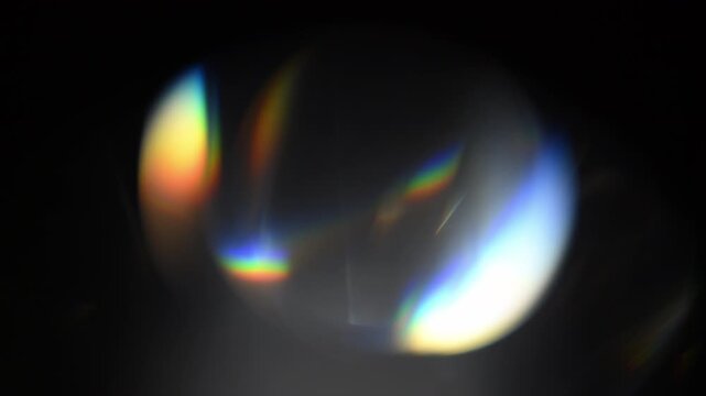 Large lens flares with colorful light reflections moving across the center of the frame. Perfect for overlay use on video projects, adding cinematic glow, motion and optical light effects.