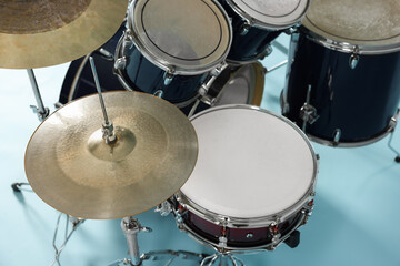 Fototapeta premium Modern drum kit on light blue background, closeup