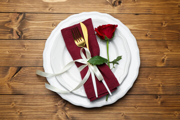 Beautiful table setting with rose on wooden background, top view