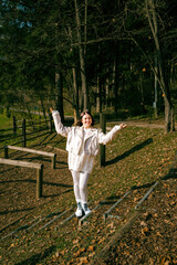Young caucasian female balancing on path in autumn forest
