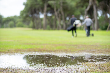 A man and a woman are walking on a golf course