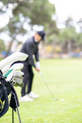 A man is playing golf and has his clubs in a bag