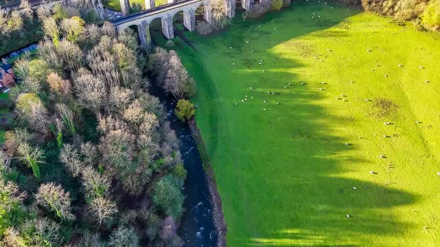 An aerial view panning up towards the south side of the viaduct and aqueduct at Chirk, Wrexham, Wales
