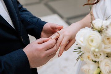 A guy puts an engagement ring on his girlfriend's finger, close-up photo. An offer of a hand and a heart. Wedding ring