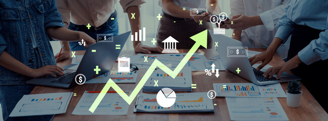 A diverse business team engages in a collaborative meeting focused on analyzing financial growth through data charts and technology, showcasing teamwork and strategic planning. Trope