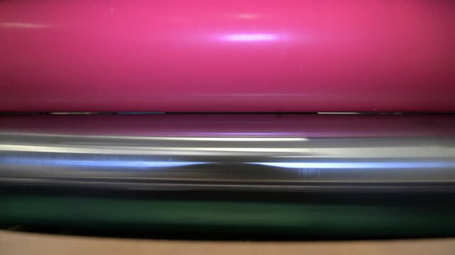 Rotating shafts of an industrial laminator in close-up at a printing plant